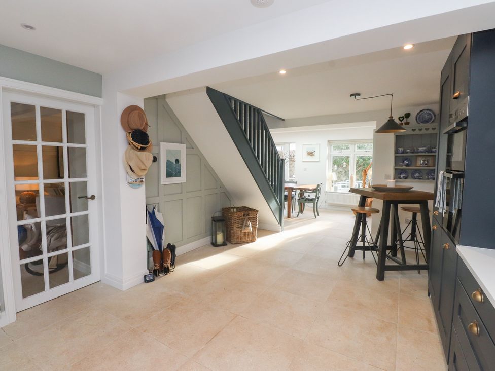 A kitchen with stairs and a table at The Music Box in Beaumaris