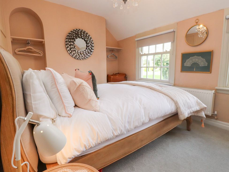 A bedroom with a bed and a window at The Music Box in Beaumaris