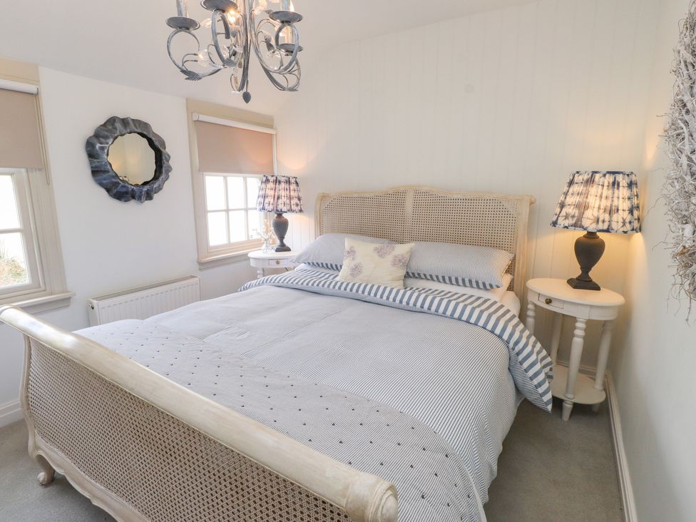 A bedroom with a bed and bedside tables at The Music Box in Beaumaris