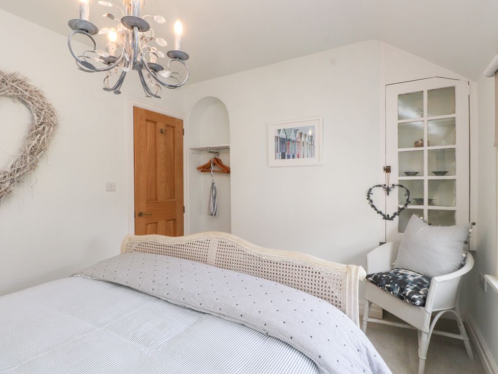 A bedroom with a bed and a wardrobe at The Music Box in Beaumaris