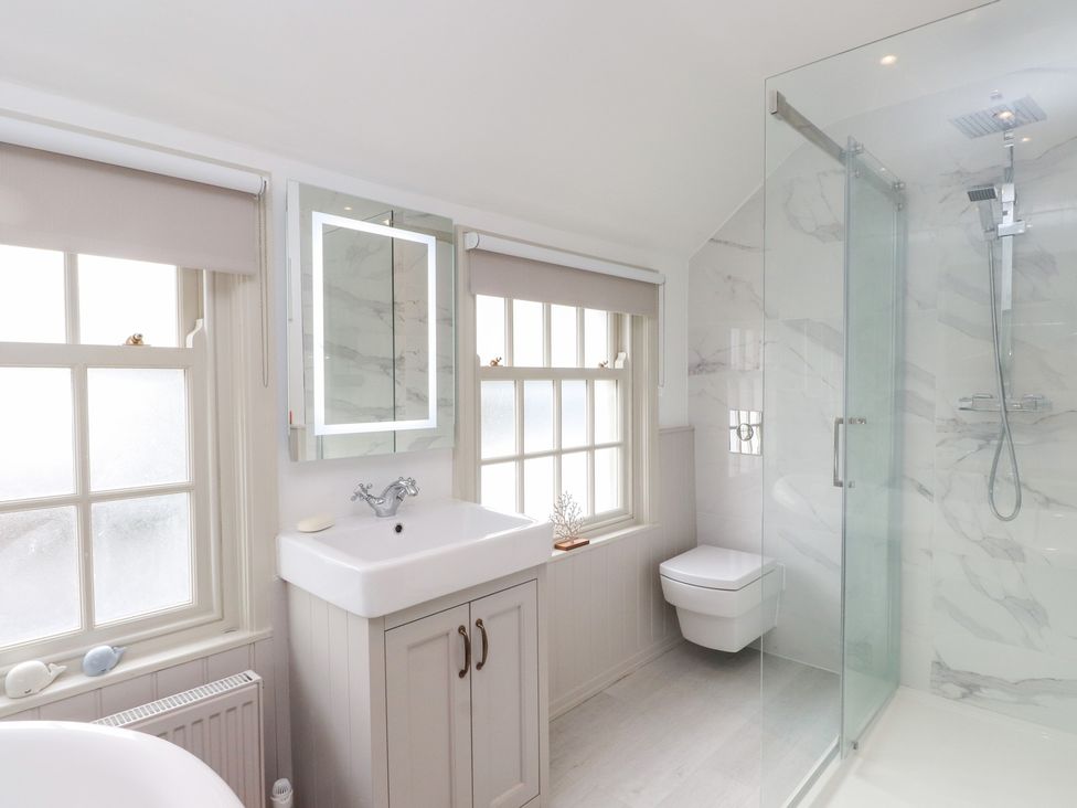 A bathroom featuring a sink, shower, and toilet at The Music Box in Beaumaris