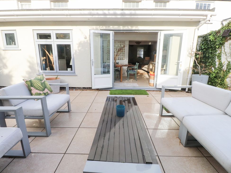 A garden with outdoor seating and a table at The Music Box in Beaumaris