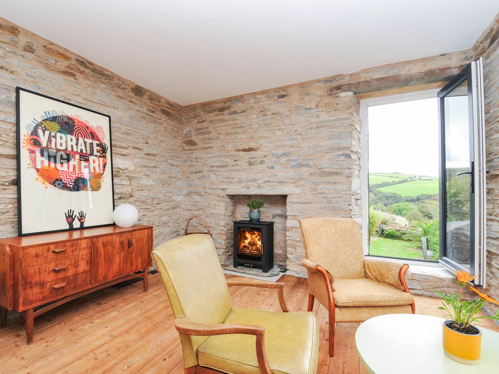 A living room with chairs and a fireplace at Boscabrea near Tintagel
