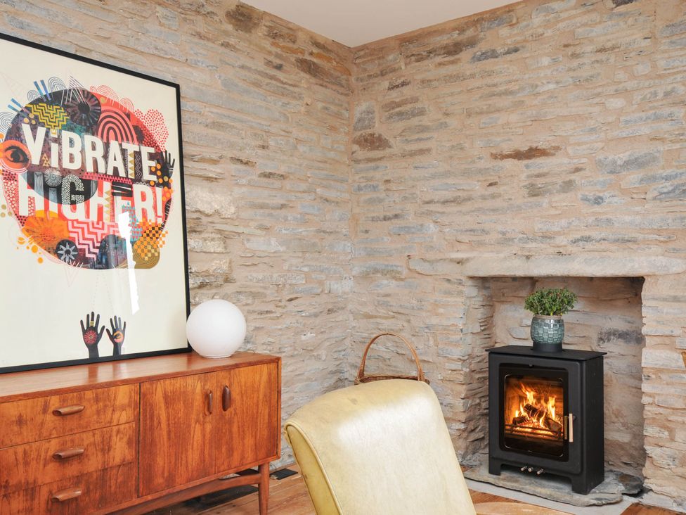 A living room with a fireplace and artwork at Boscabrea near Tintagel
