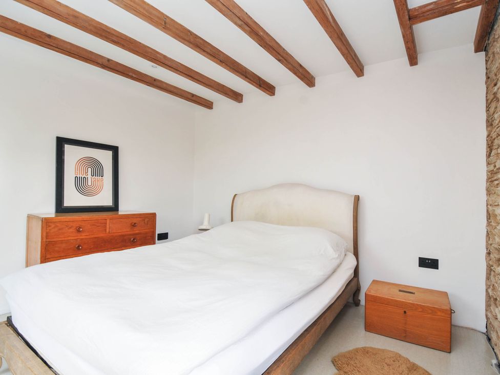 A bedroom with a bed and wooden furniture at Boscabrea near Tintagel