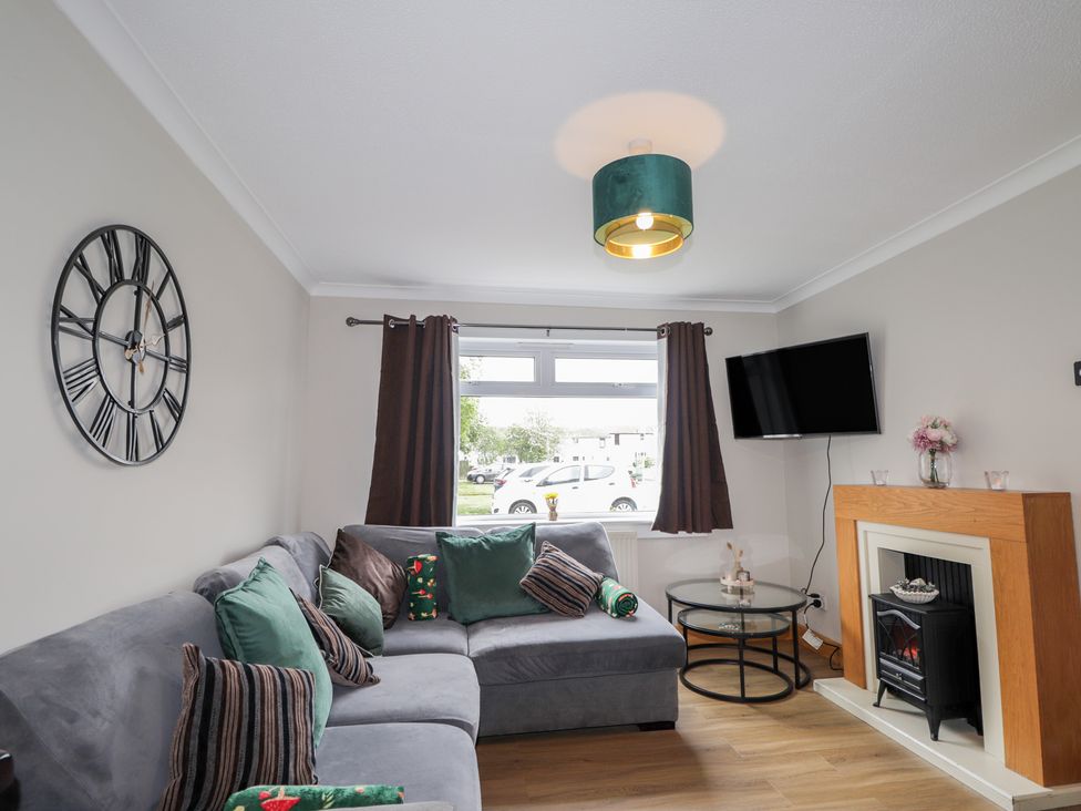 A living room with a sofa and television at Clans Crescent in Nairn