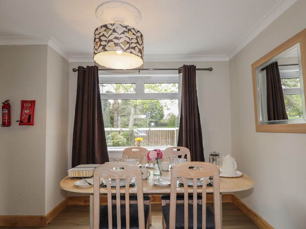 A dining room with a table set for meals at Clans Crescent in Nairn