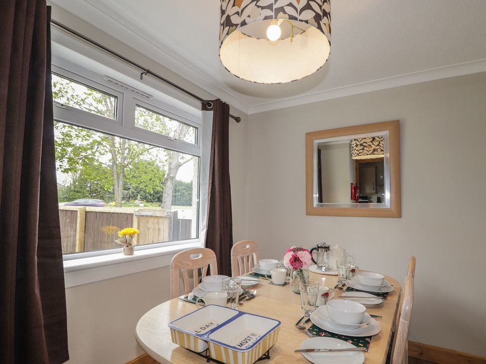 A dining room with a table set for meals at Clans Crescent in Nairn