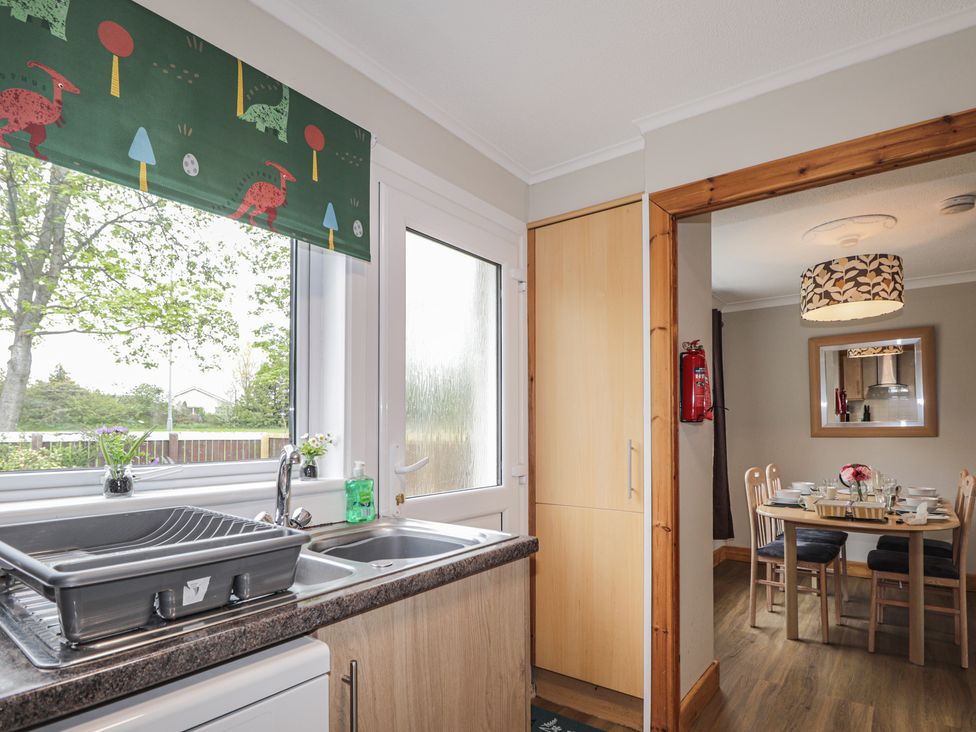 A kitchen with a sink and a table set at Clans Crescent Nairn