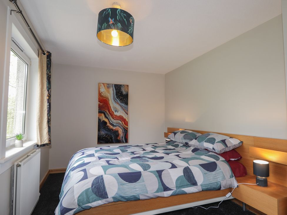 A bedroom with a bed and a painting at Clans Crescent in Nairn