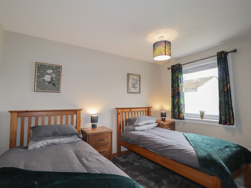 A bedroom with two beds and wall art at Clans Crescent in Nairn