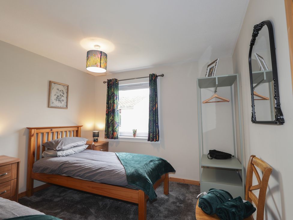 A bedroom with a bed and storage furniture at Clans Crescent in Nairn