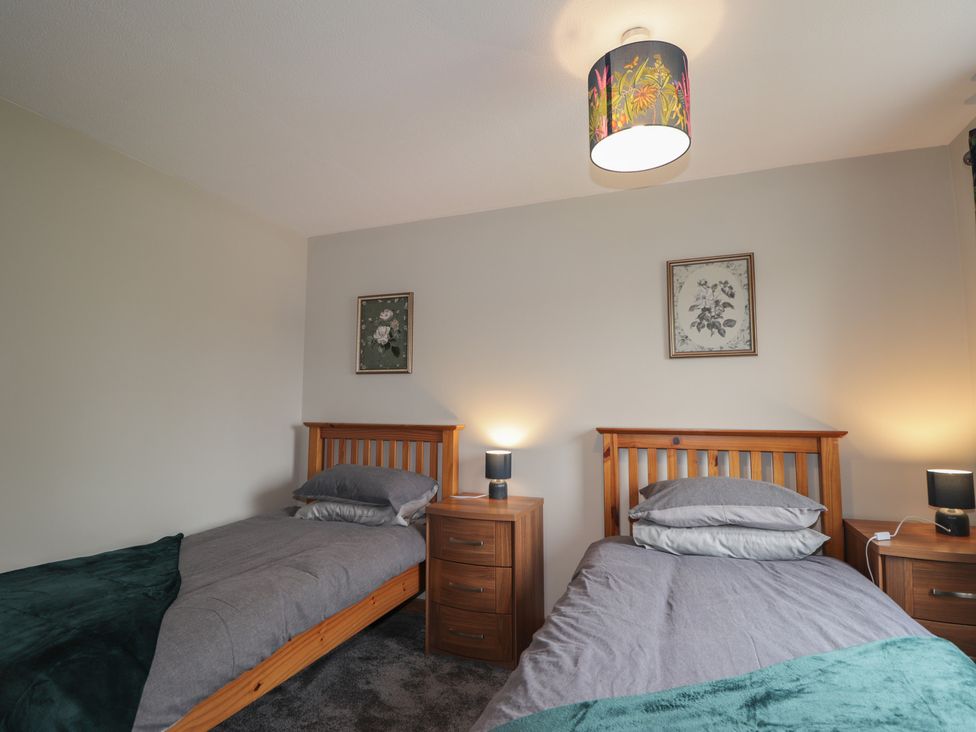 A bedroom with two beds and nightstands at Clans Crescent in Nairn
