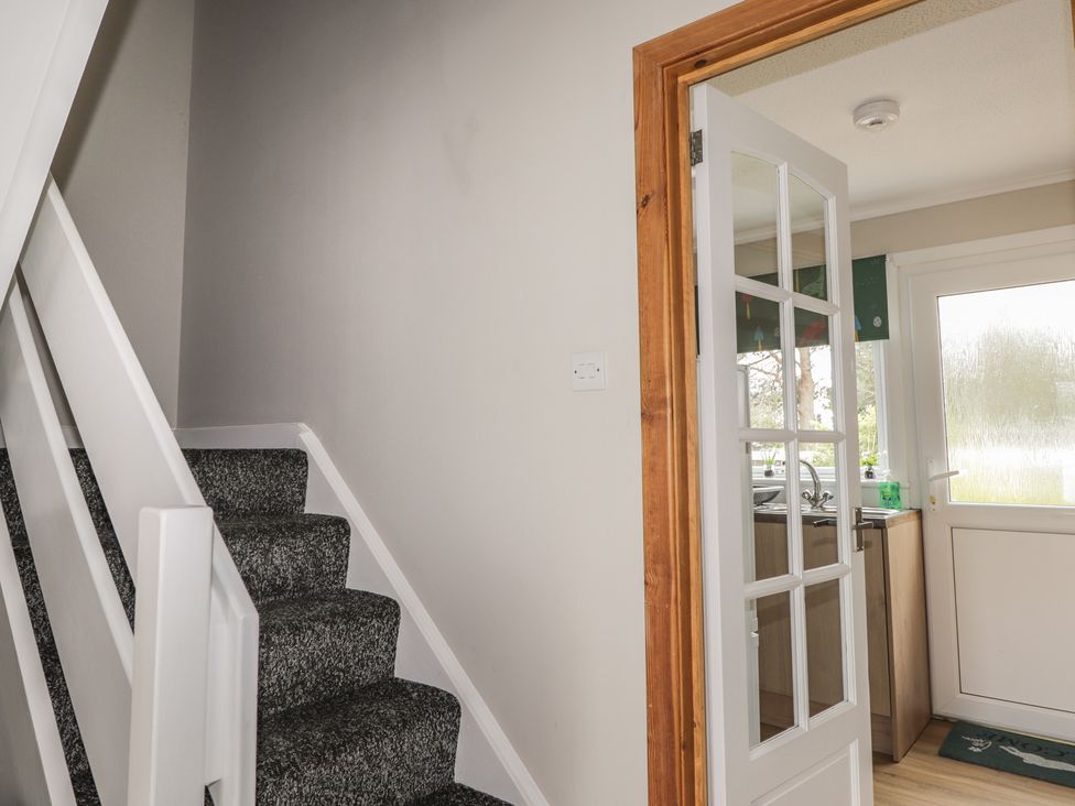 A staircase and door leading to a kitchen at Clans Crescent Nairn