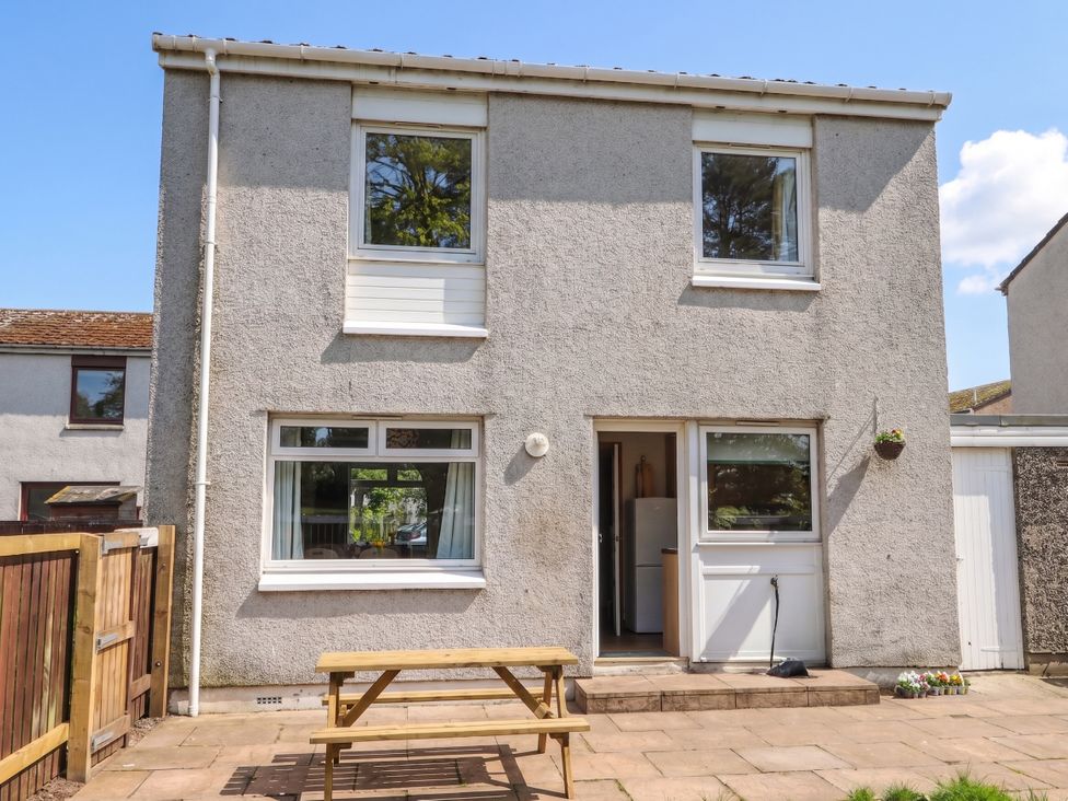 A house exterior with a patio and table at Taigh Ban Nairn