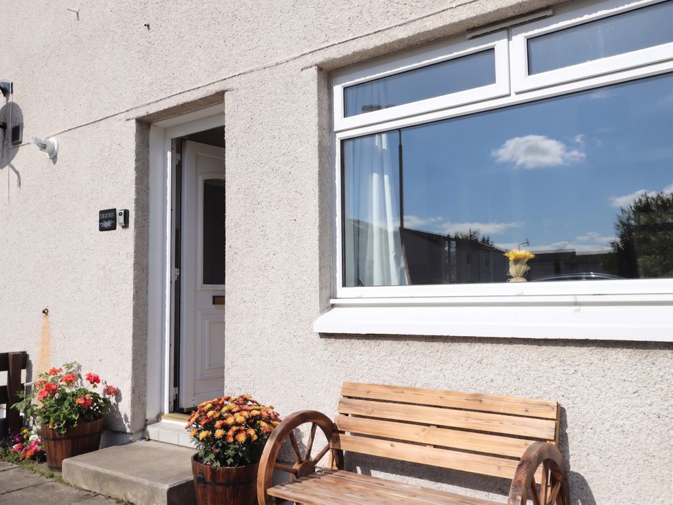 A front entrance with a bench and flower pots at Taigh Ban in Nairn
