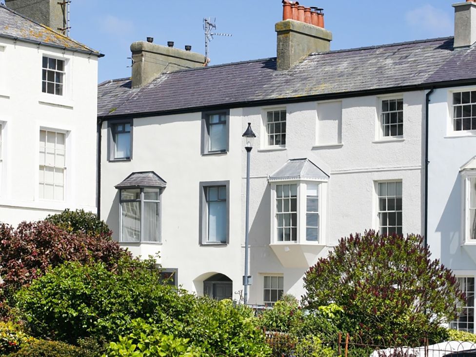 A view of houses with windows and a garden at Tri Raglan Bach in Beaumaris