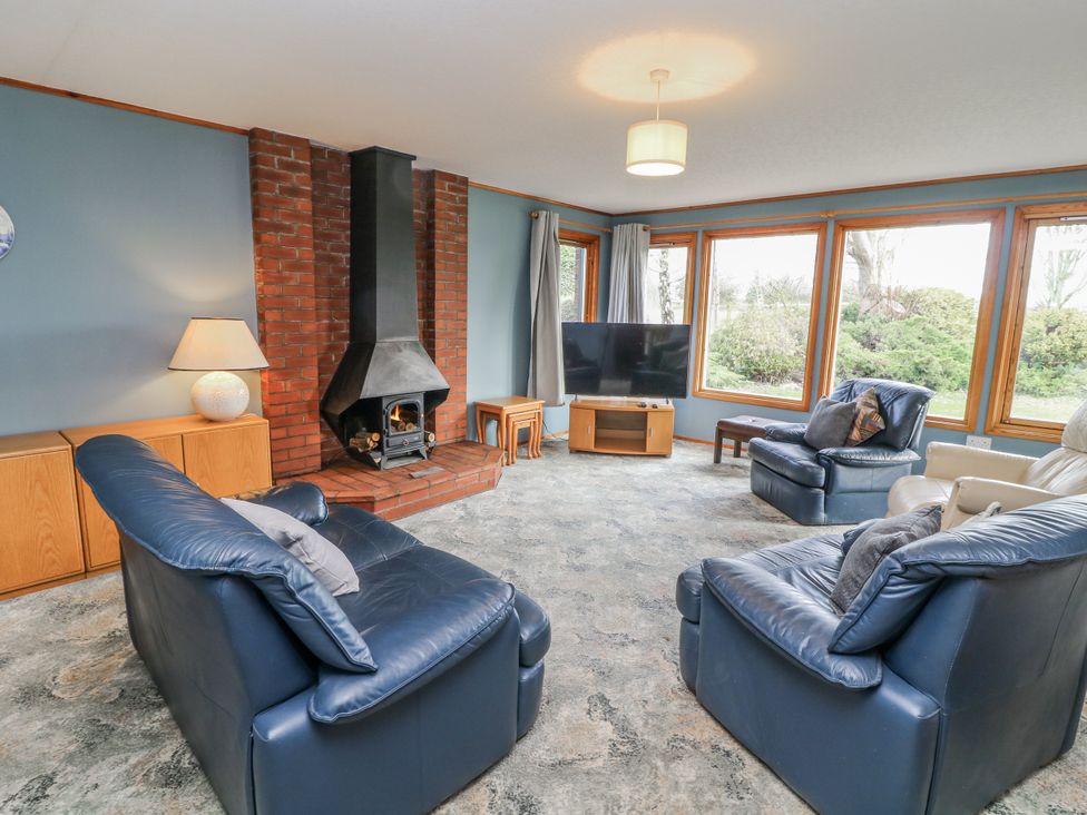 A living room with a fireplace and seating area at Cherry Trees 