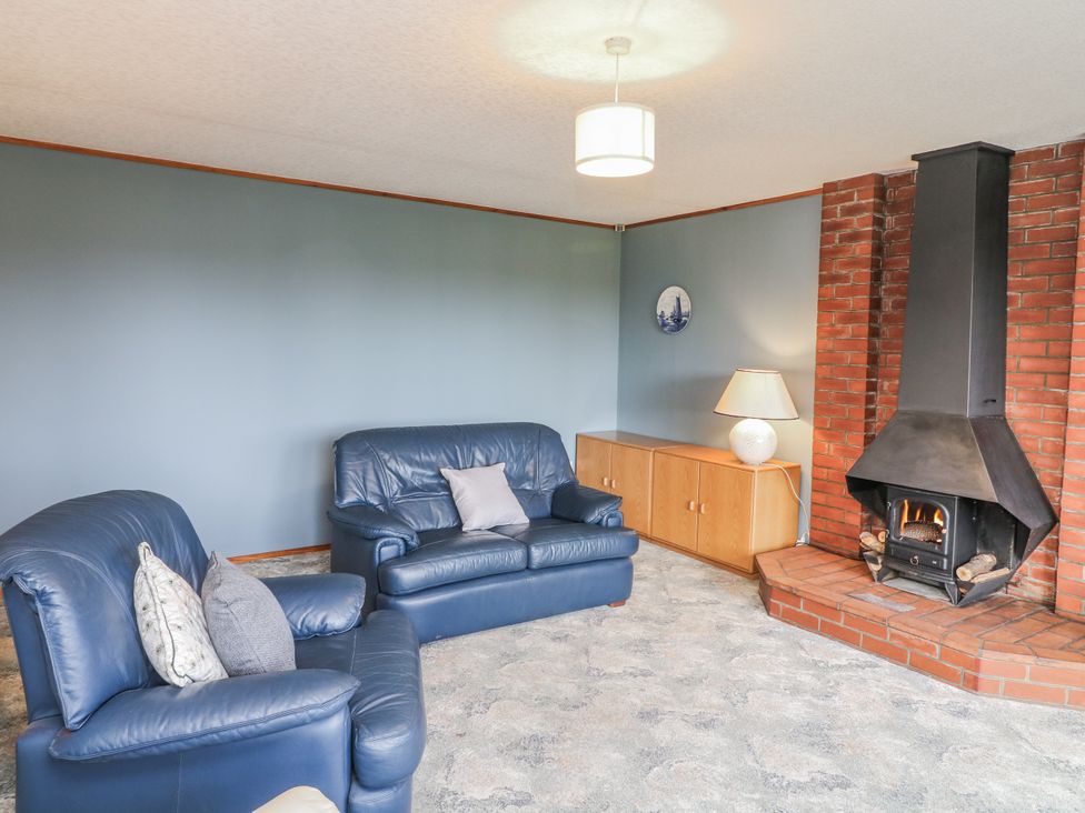 A living room with a blue sofa and fireplace at Cherry Trees 