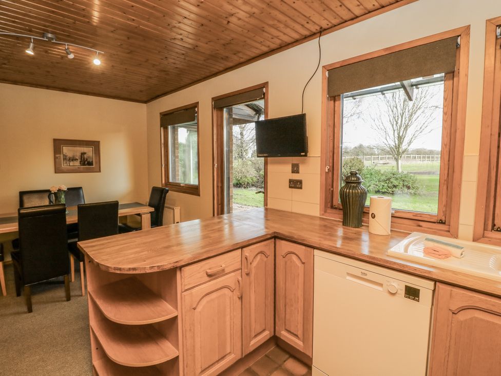 A kitchen with cabinetry and dining area at Cherry Trees 