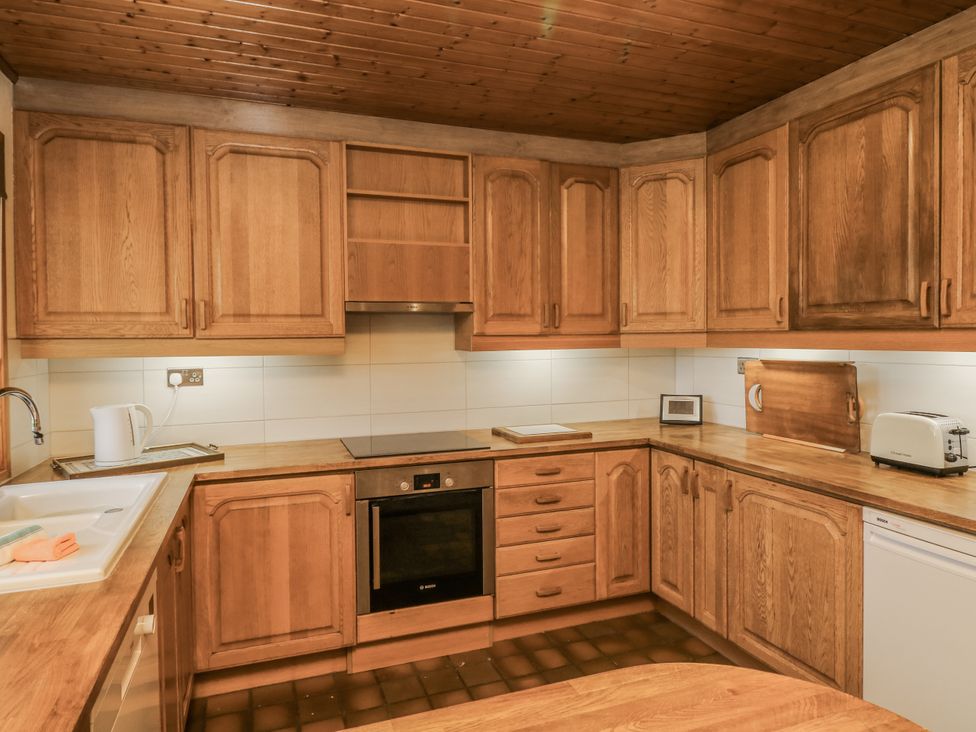 A kitchen with wooden cabinets and appliances at Cherry Trees