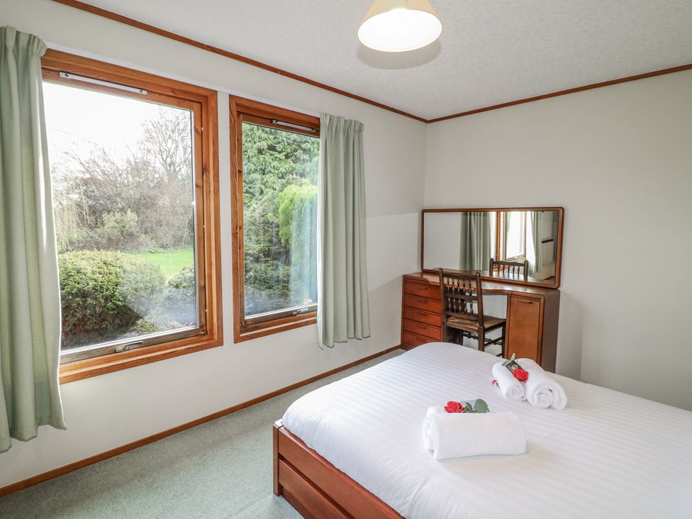 A bedroom with a bed and dresser at Cherry Trees
