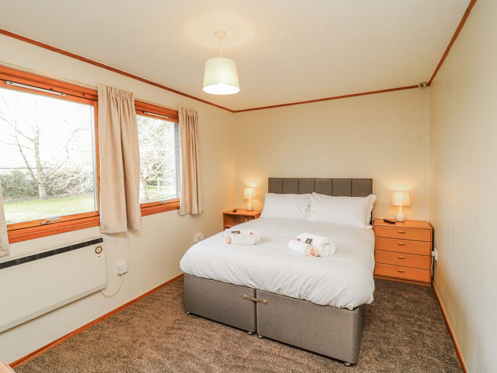 A bedroom with a bed and windows at Cherry Trees