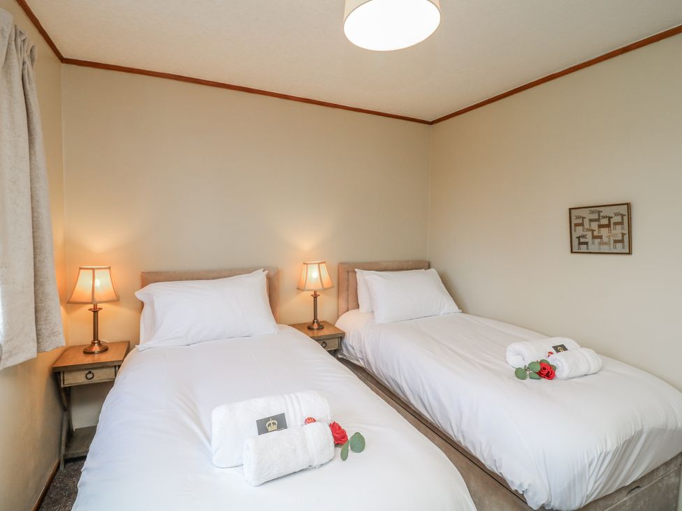 A bedroom with twin beds and bedside lamps at Cherry Trees