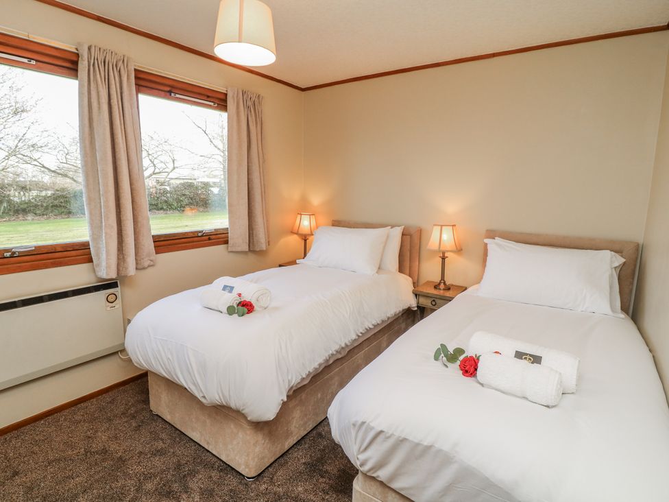 A bedroom with twin beds and a bedside table at Cherry Trees 