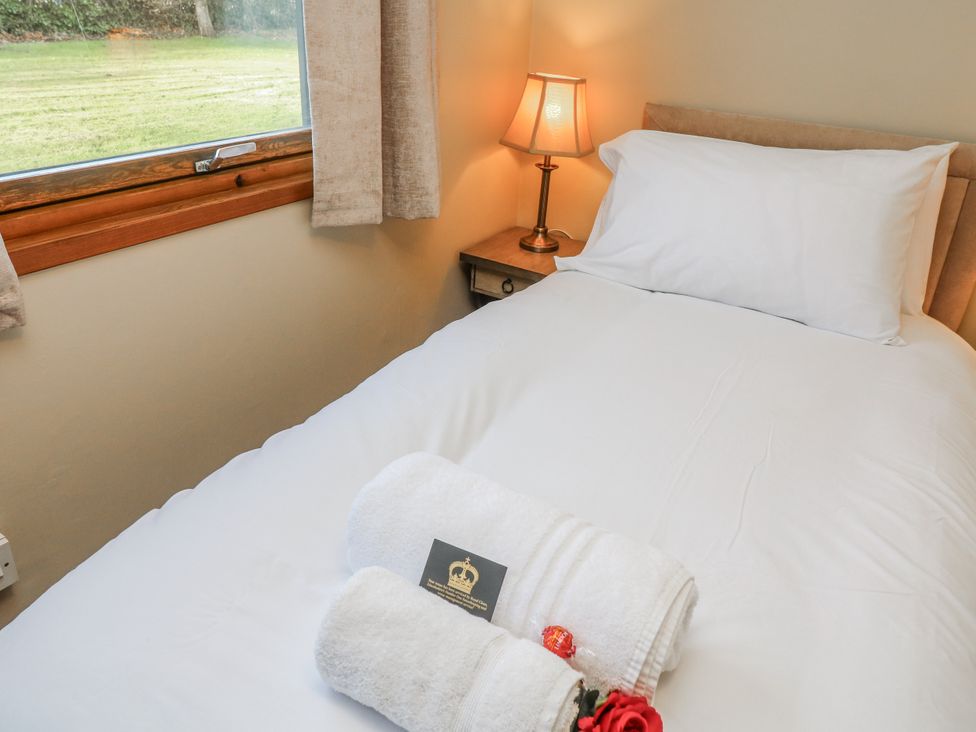 A bedroom with a bed and lamp at Cherry Trees 