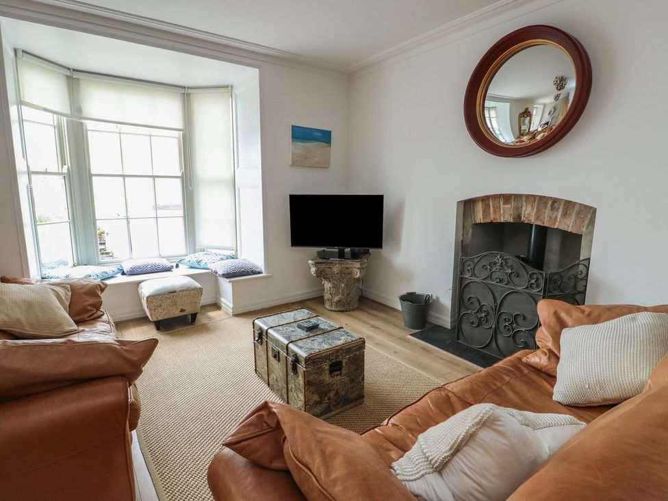 A living room with a television and a fireplace at Tri Raglan Mawr in Beaumaris