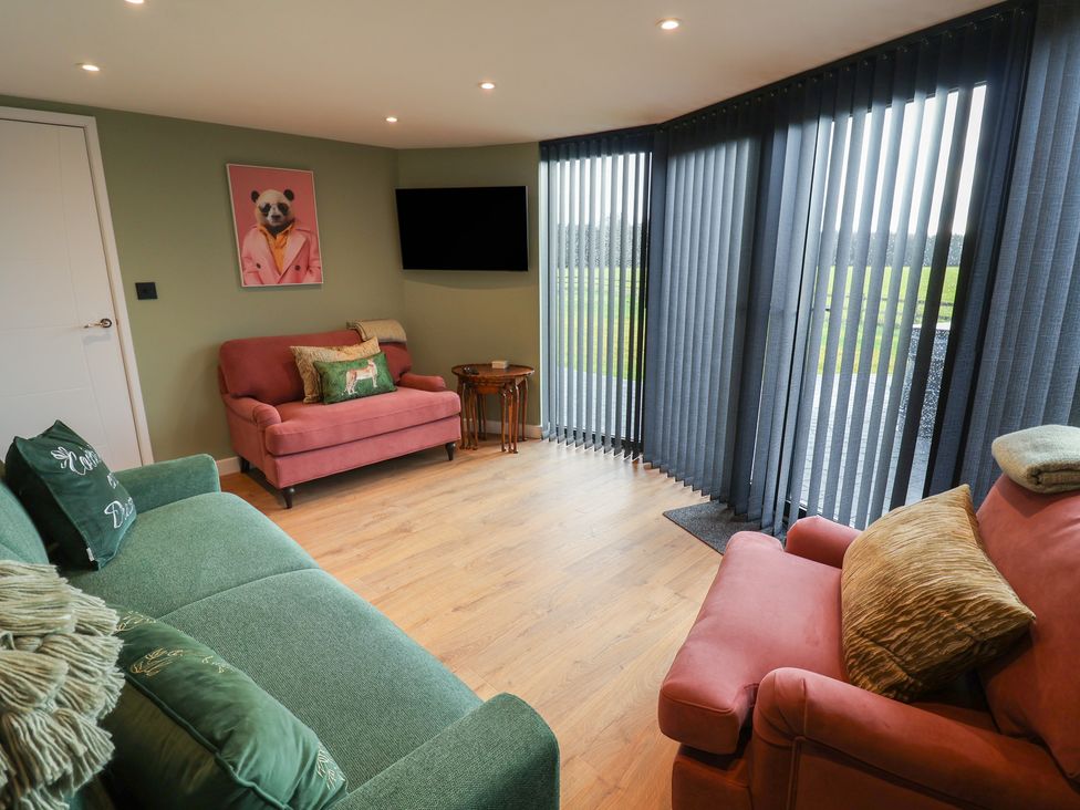 A living room with a television and seating at Unit 1 in Ipswich