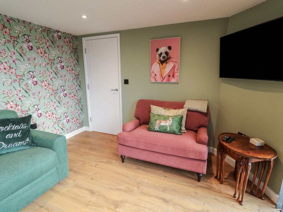 A living room with a pink sofa and green armchair at Unit 1 in Ipswich