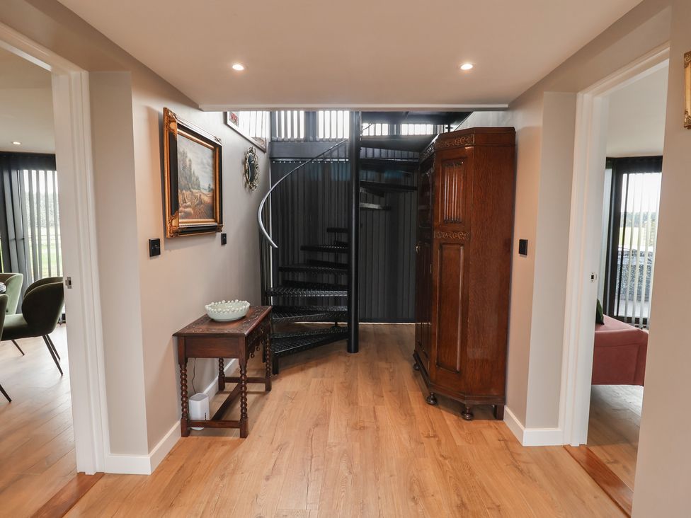 A hallway with a staircase and cabinets at Unit 1 Ipswich