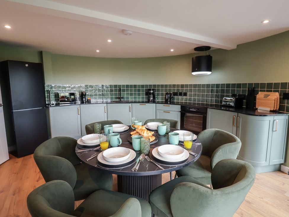 A kitchen with a dining table and appliances at Unit 1 Ipswich