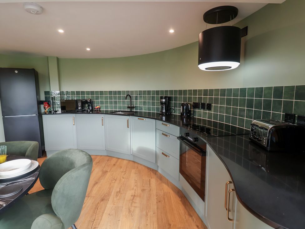 A kitchen with modern appliances and curved countertops at Unit 1 Ipswich