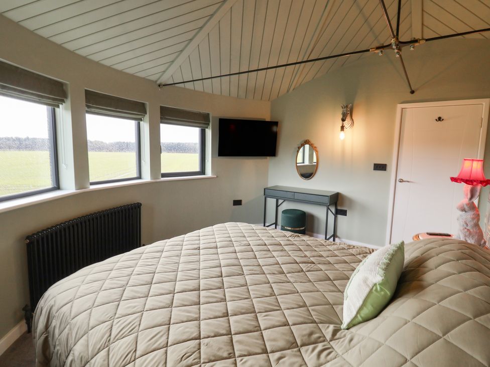 A bedroom with a bed and television at Unit 1 Ipswich