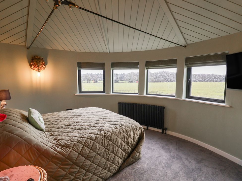 A bedroom with a bed and windows at Unit 1 in Ipswich