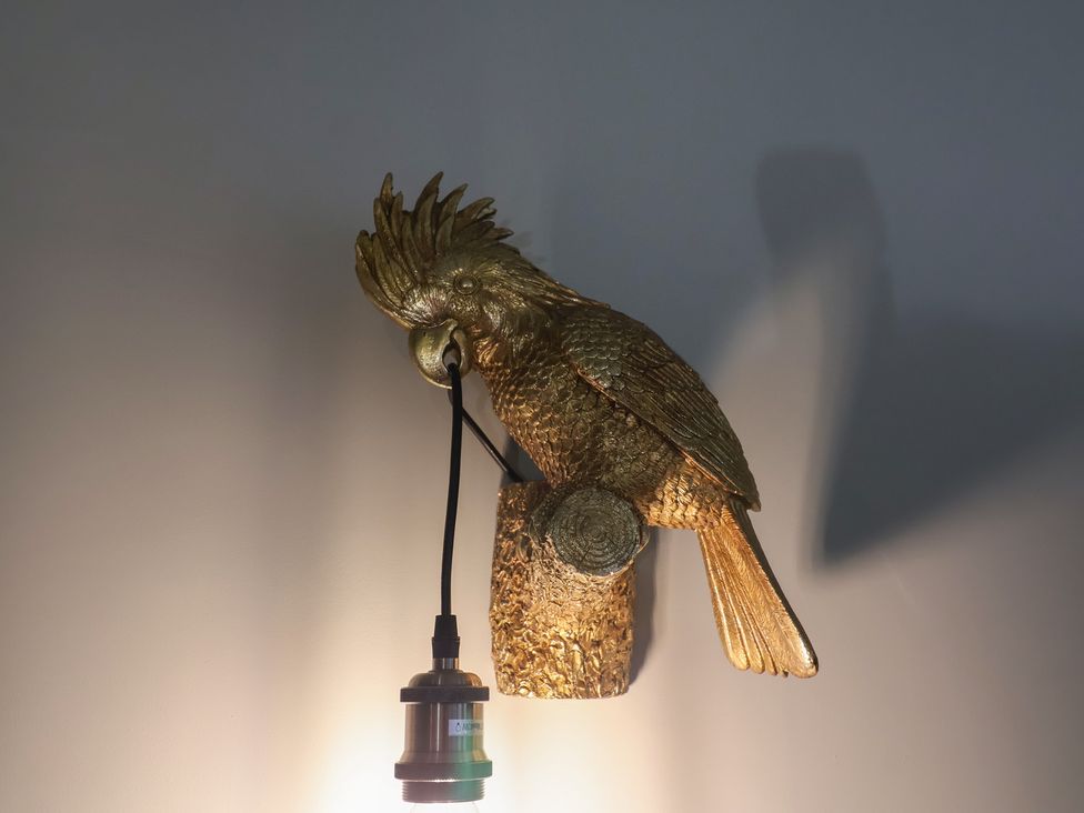 A bird sculpture lamp mounted on a wall at Unit 1 Ipswich