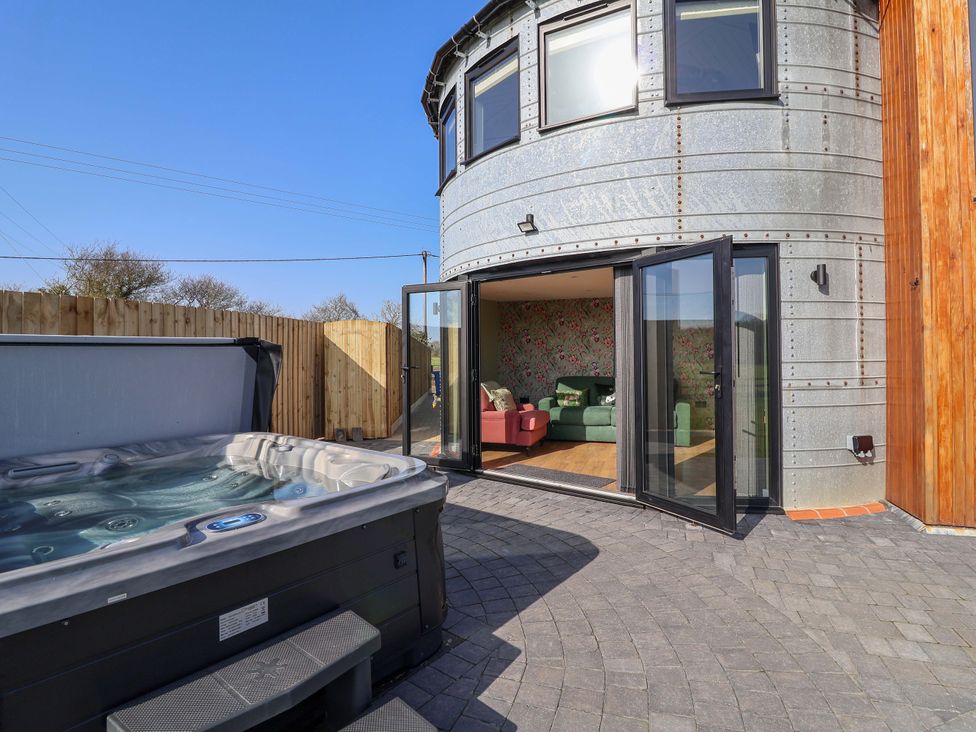 An outdoor area with a hot tub and an entrance to a living room at The Corn Silo in Ipswich