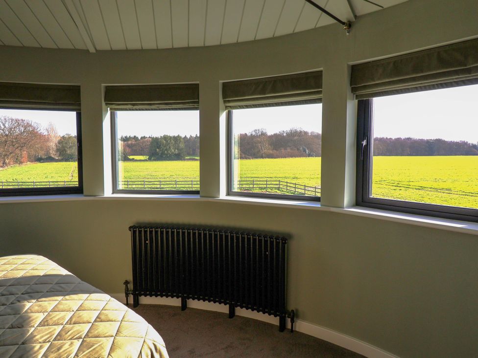 A bedroom with windows and a radiator at The Corn Silo in Ipswich