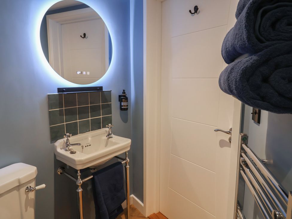 A bathroom with a sink, mirror, and towels at Unit 2 Ipswich