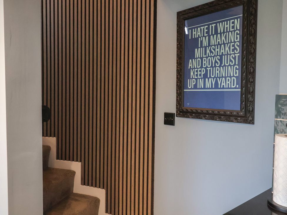 A staircase with wood paneling and framed artwork at Unit 2 in Ipswich