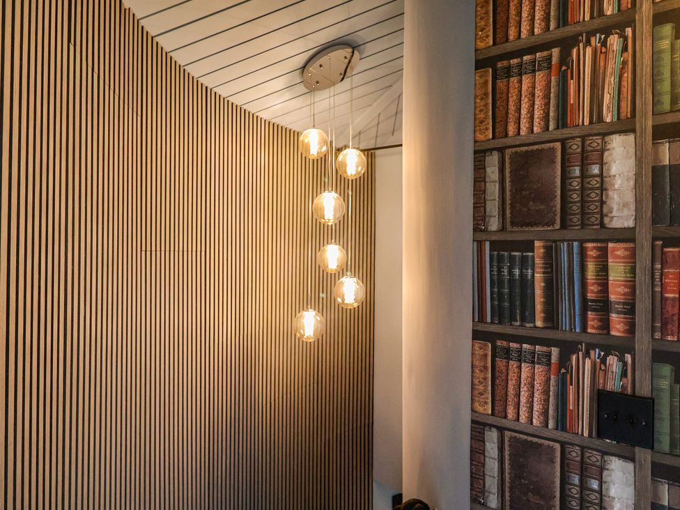 A hallway featuring wood paneling and a pendant light fixture at Unit 2 Ipswich