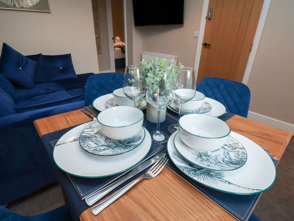 A dining table set with plates and glasses at Apartment 2, Blackburn Heights Bridlington