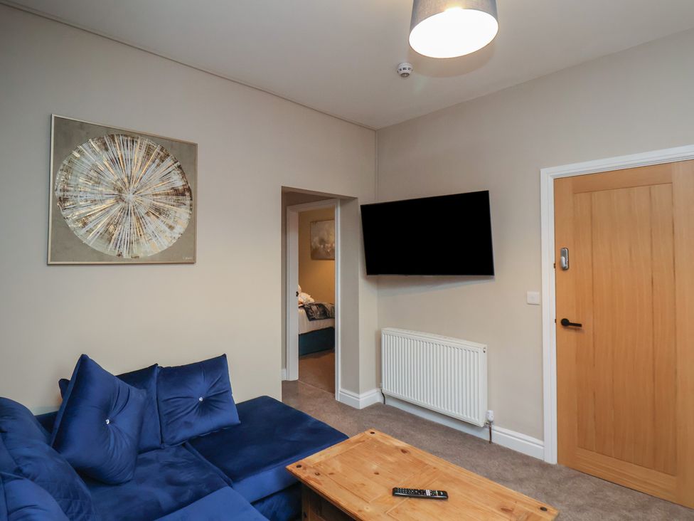 A living room with a sofa and a TV at Apartment 2, Blackburn Heights in Bridlington