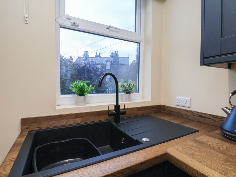 A kitchen with a sink and plants at Apartment 2, Blackburn Heights in Bridlington