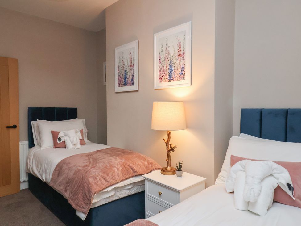 A bedroom with two beds and a lamp at Apartment 2, Blackburn Heights Bridlington