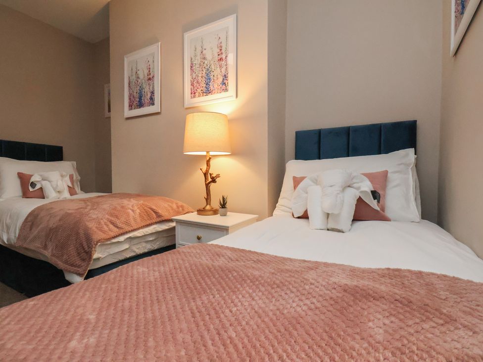 A bedroom with two beds and a lamp at Apartment 2, Blackburn Heights in Bridlington
