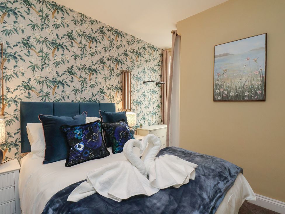 A bedroom with a bed and decorative pillows at Apartment 2, Blackburn Heights in Bridlington